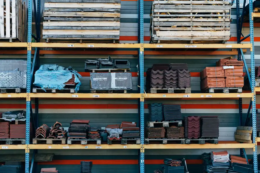 Roof tiles and ridge tiles racked on pallets inside a builders merchant warehouse