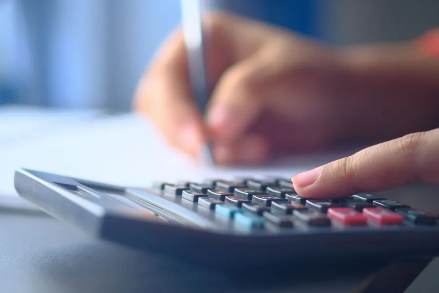 Working through the cost of a roof repair with a calculator and notes