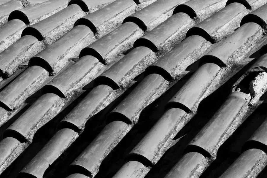 Close-up of old weathered roof tiles with one cracked, the kind of wear an insurer calls gradual deterioration