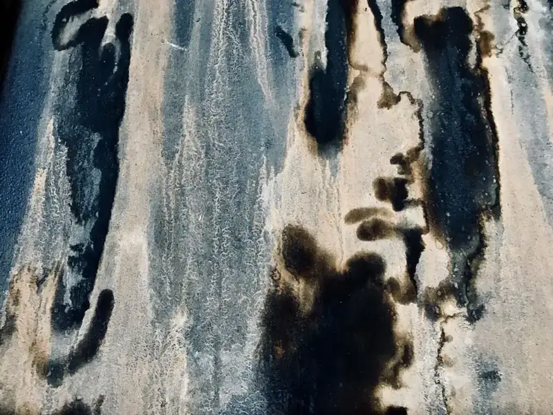 Dark water staining running down an internal wall from persistent roof ingress