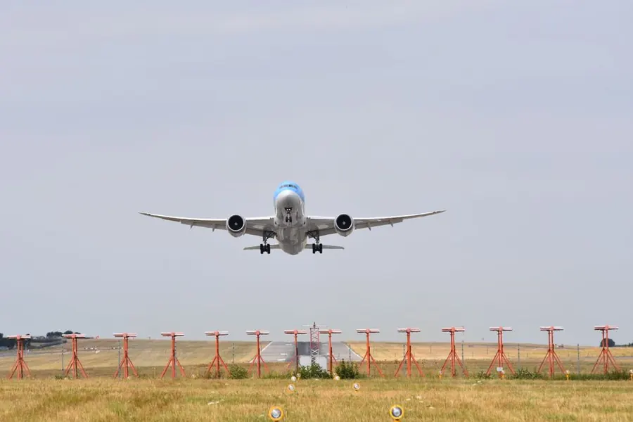 Airliner low over the approach lights at an airport runway