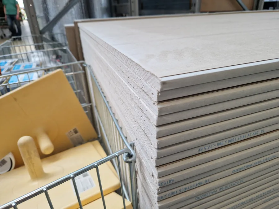 Stacked 12.5mm plasterboard sheets at a builders merchant in west London