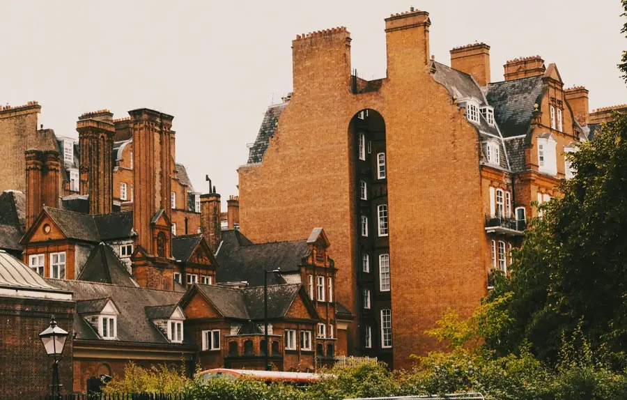 Red brick Queen Anne style houses with gables, clay tile roofs and tall chimney stacks, typical of Bedford Park in Chiswick