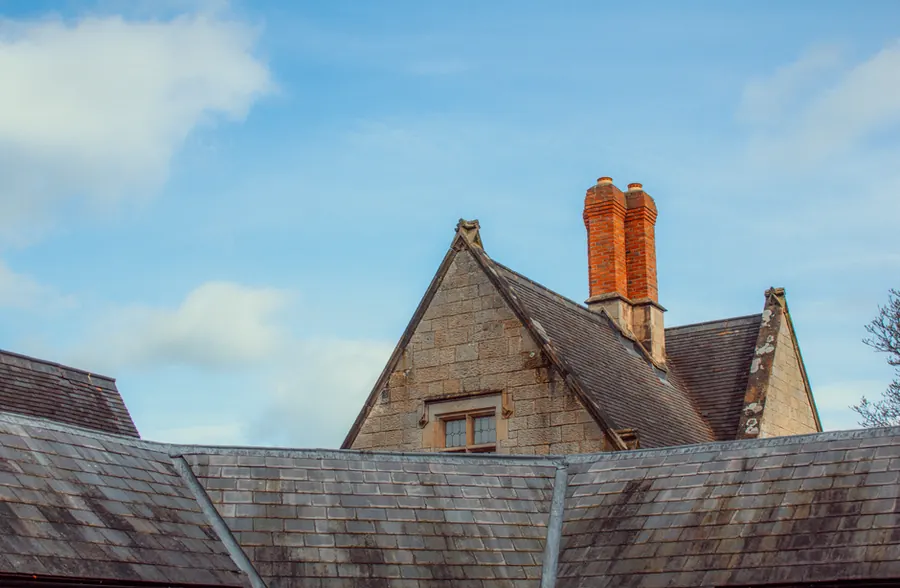 Repointed brick chimney stack with clay pots and a sound mortar flaunching
