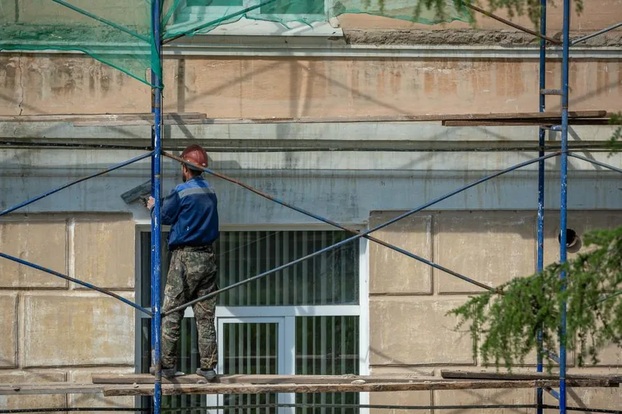Scaffolding erected against a terraced building for roof and facade repairs