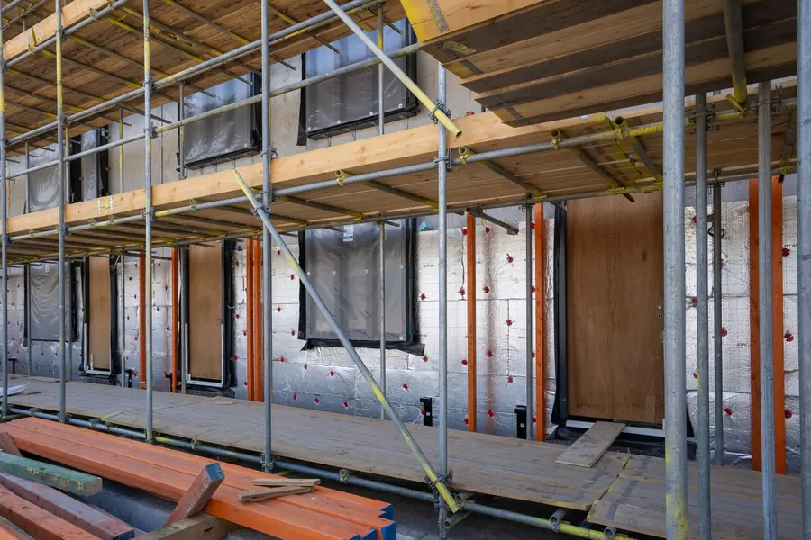 Scaffold tube and boards erected around a residential building under refurbishment