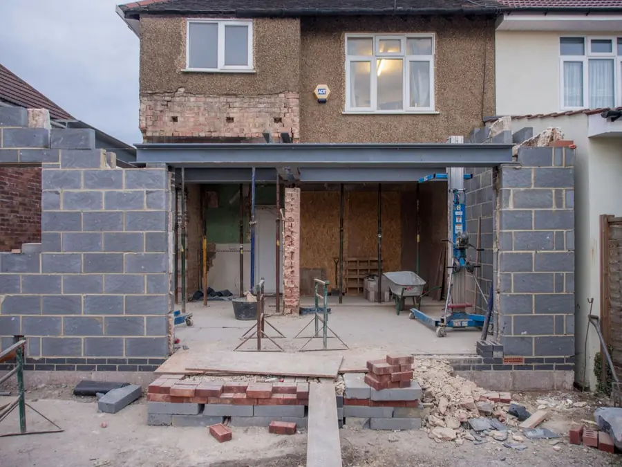 Rear of a west London terraced house with an extension under construction and the main roof visible above