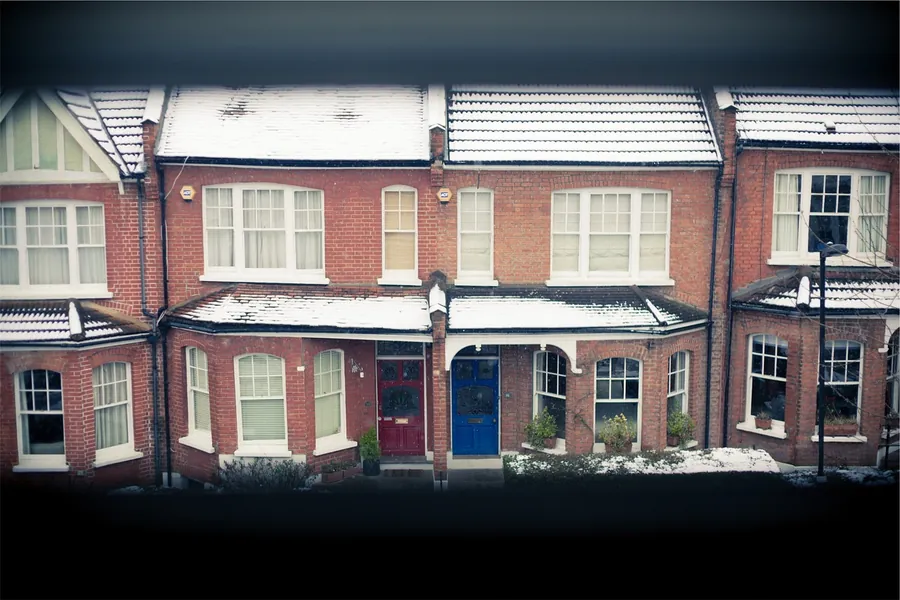 Red brick Victorian terraced houses with slate roofs, bay windows and chimney stacks, similar to the Four Roads streets in Isleworth