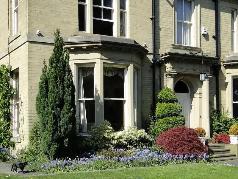 A pale stone-faced Victorian villa with bay windows and a front garden, similar in style to the early houses on the Spring Grove estate