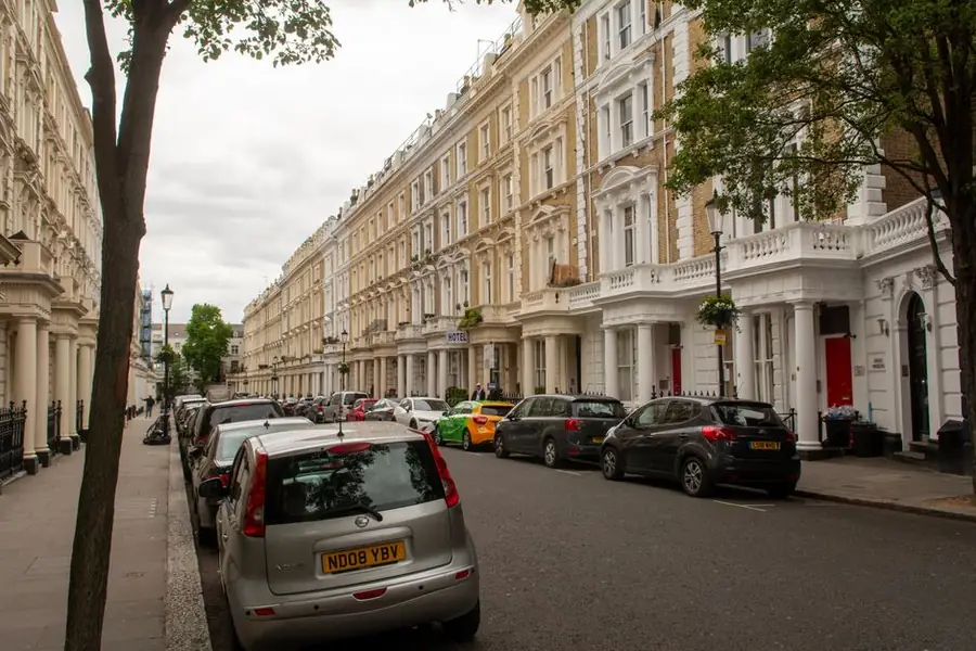 Victorian terraced street in London with cars parked along it
