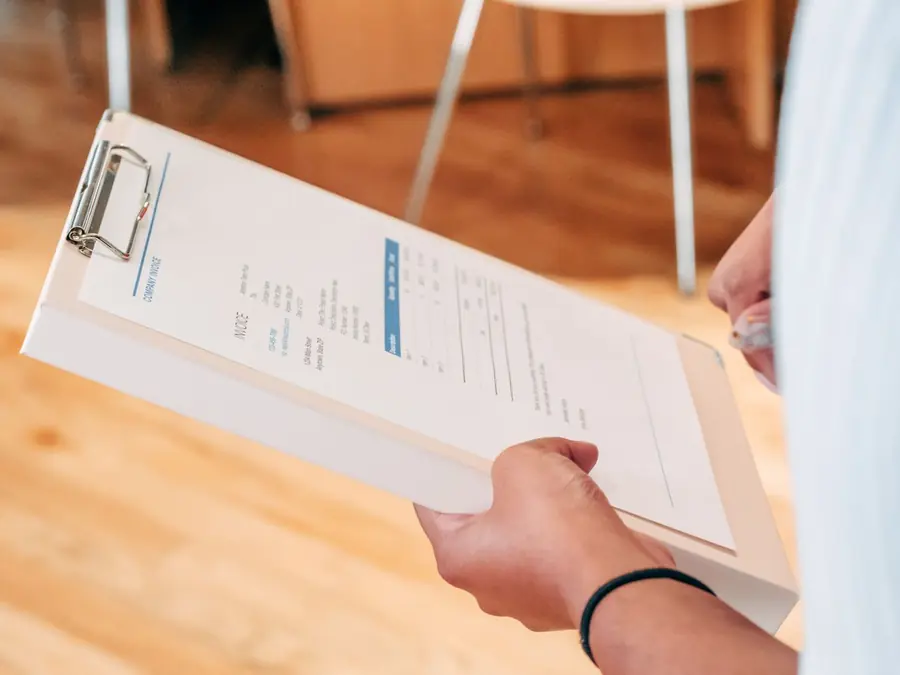 Written report held on a clipboard, like the roof condition report that backs up a storm claim