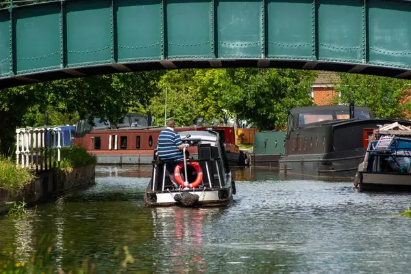 White-arched canal bridge at a junction of waterways with moored narrowboats