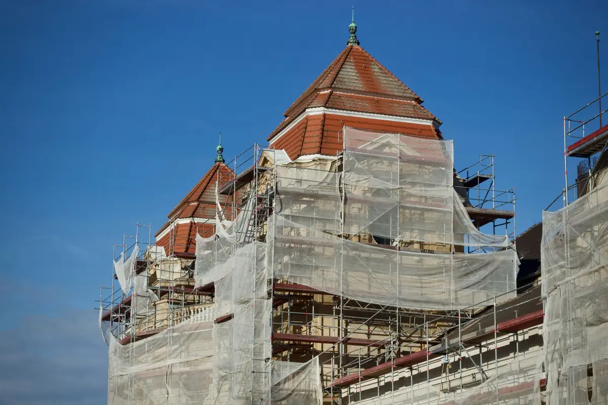 Roof wrapped in protective sheeting and scaffold during emergency repairs