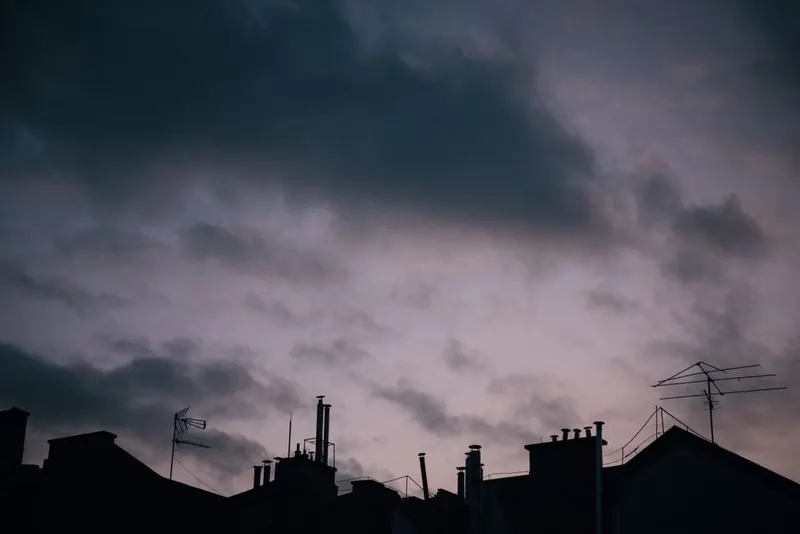 Dark rain clouds gathering over the rooftops of terraced streets in Hounslow