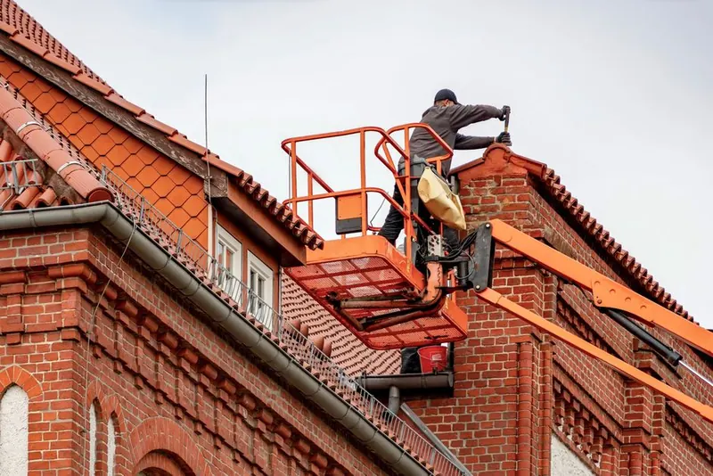 Roofer working at roof height from a powered access platform