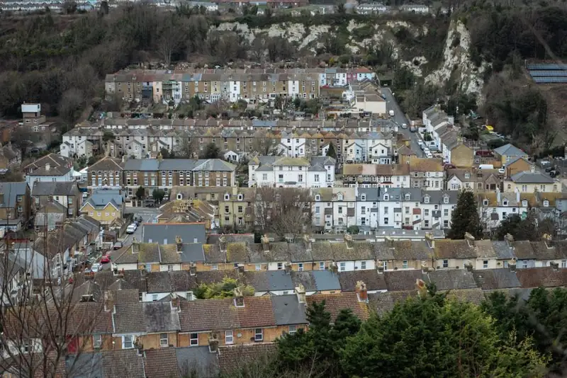 Heavy grey cloud hanging over rows of terraced houses