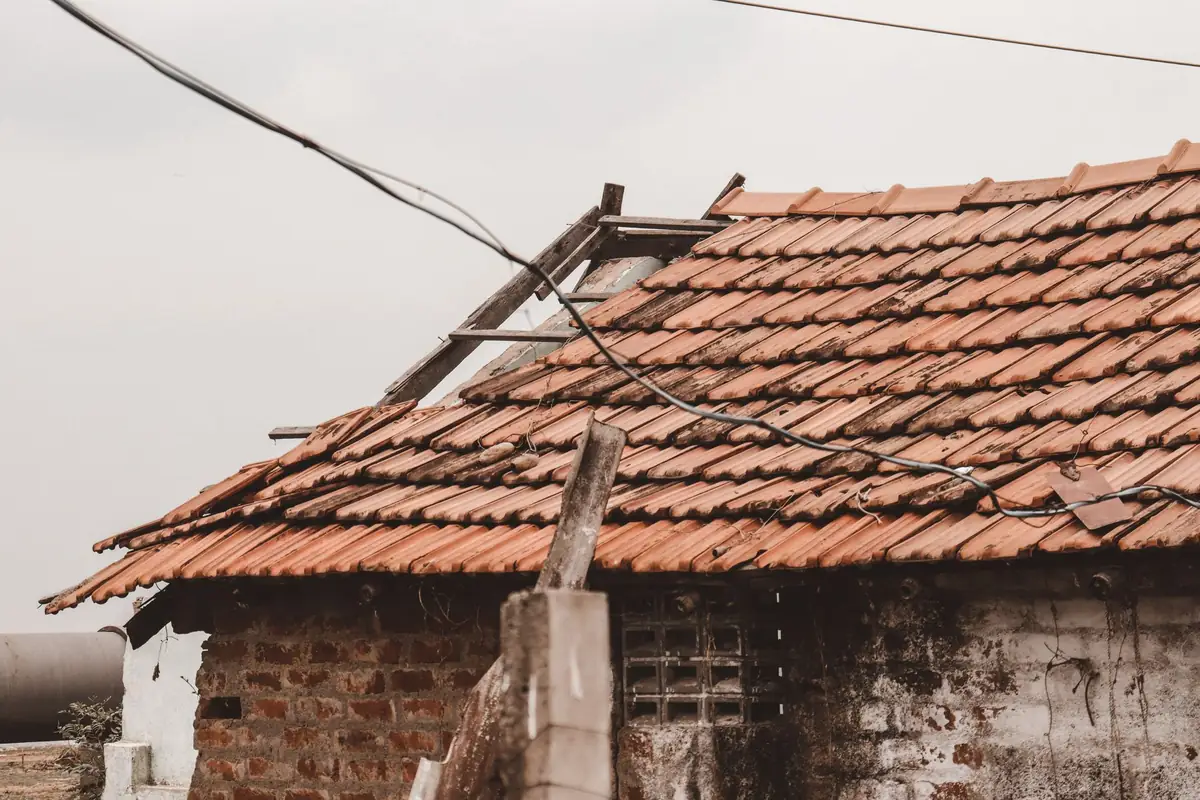 Pitched roof with tiles stripped away and battens exposed after storm damage